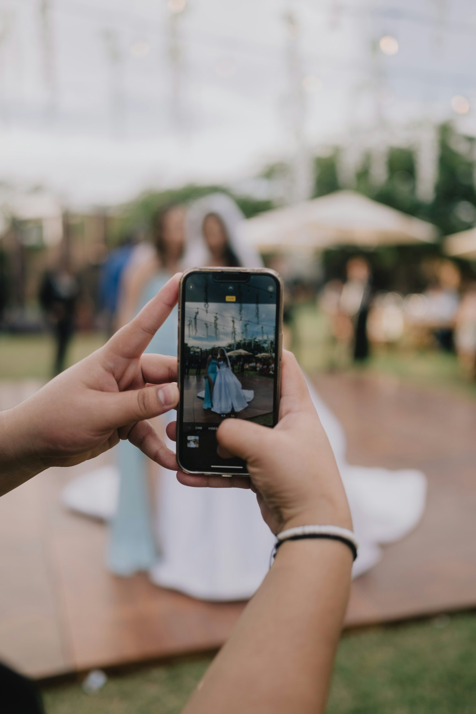 A guest photographing the bride on a phone